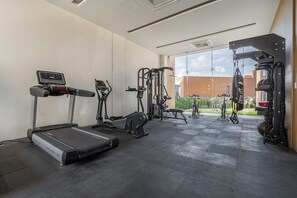 Ein Fitnessstudio mit Cardiogeräten, Kraftmaschinen und einem Bereich für Klimmzüge.