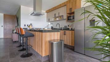 Una cocina moderna con una isla central, electrodomésticos de acero inoxidable y armarios de madera.
