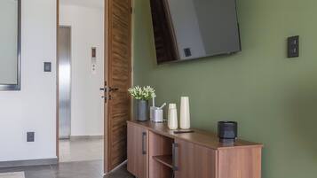 Een moderne hal met een houten kast, een grote spiegel en een betegelde vloer.