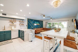 Een moderne keuken met een eethoek, een plafondventilator en uitzicht op de omgeving.