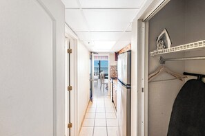 A corridor with a kitchen area, a dining table, and a view of the outdoors. - Amazing Oceanfront View  Condo with Pool & Hot tub (Myrtle Beach)