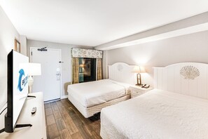 A hotel room with two beds, a desk, a lamp, and a television. - Amazing Oceanfront View  Condo with Pool & Hot tub (Myrtle Beach)