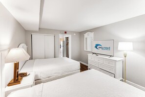 A hotel room with two beds, a television, a desk with a lamp, and a wardrobe. - Amazing Oceanfront View  Condo with Pool & Hot tub (Myrtle Beach)