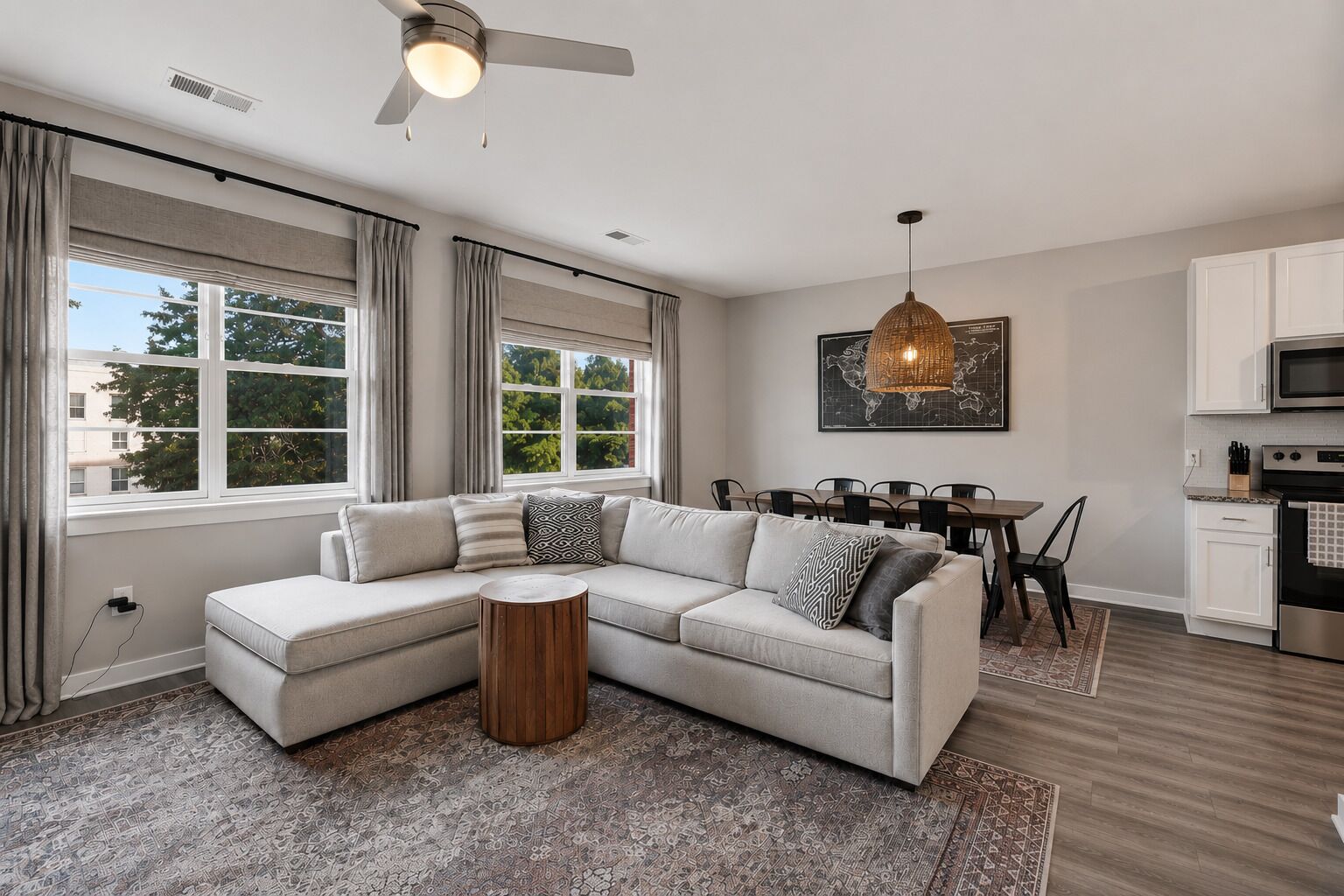 A modern living room with a sectional sofa, dining area, and kitchen.