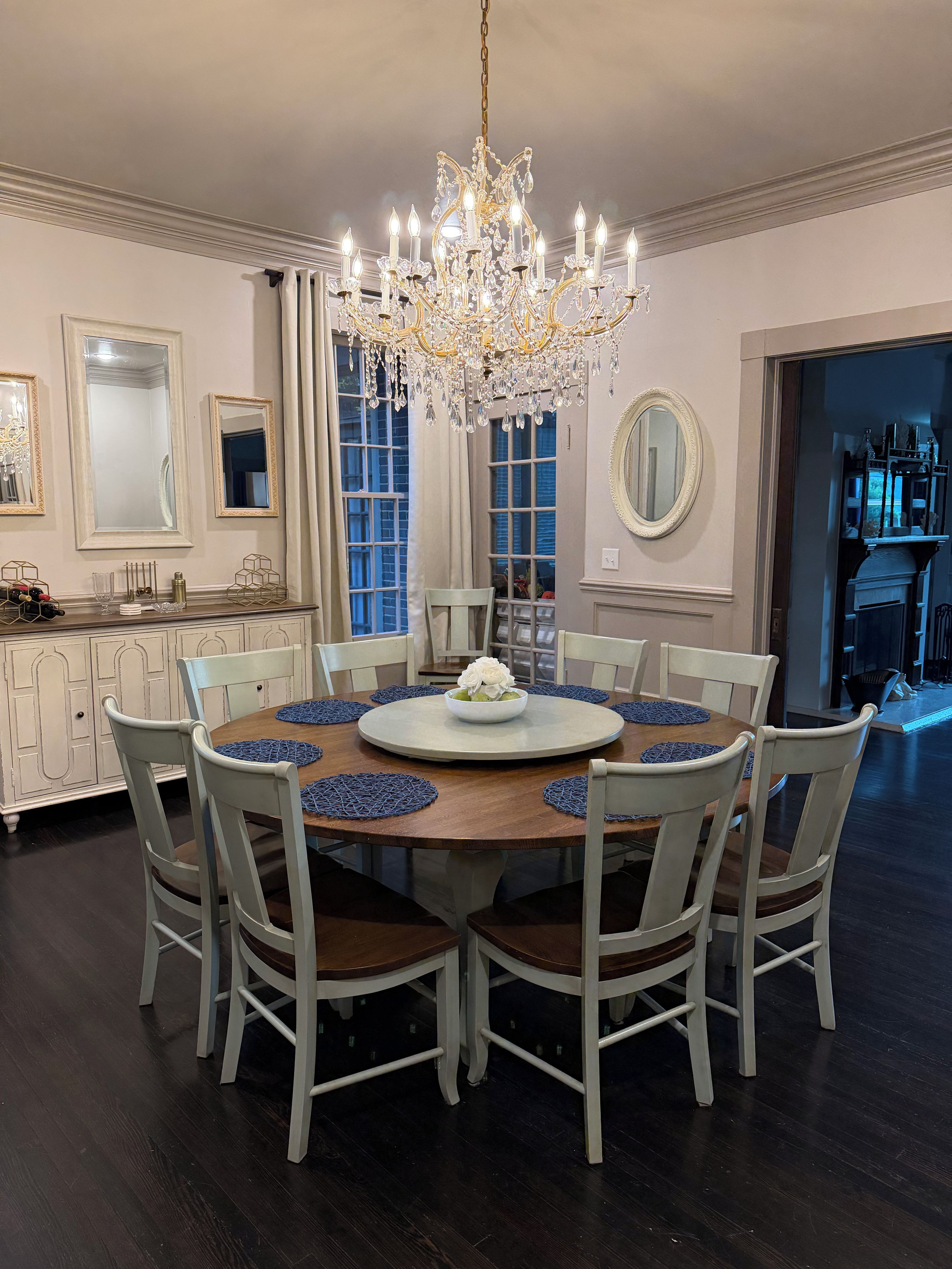 Comedor con candelabro, mesa redonda y sillas.