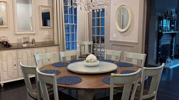 Comedor con candelabro, mesa redonda y sillas.
