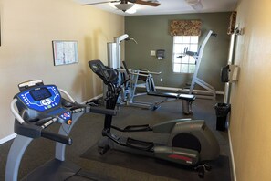 A gym with cardio equipment, a wall-mounted map, and a window with blinds. - Charming Catalina Foothills Condo w/ Mountain Views, Gym, Pool and Spa (Tucson)