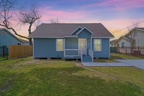 A single-story house with a front porch, a small attached garage, and a clear sky. - Cozy 3-Bedroom Suburban Retreat near Downtown (Houston)