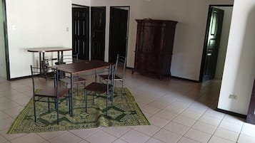 A dining area with a table and chairs, a patterned rug, and a cabinet.