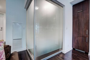 A room with a sliding glass door, a wooden wardrobe, and a white wall. - Luxury 3 bedrm 2 Baths Steps from CN Tower/Rogers Centers with One Parking Spot (Toronto)