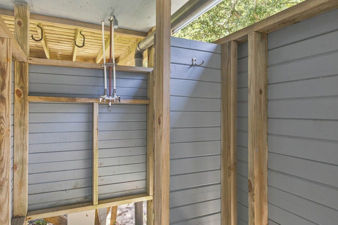 Une pièce avec une structure en bois, une fenêtre et une bouche d’aération au plafond.