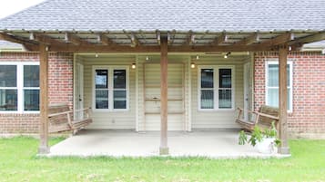 A building with a covered porch, brick walls, and a concrete floor.