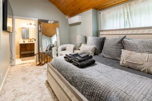 A bedroom with a bed, a bedside table, a lamp, a mirror, and a window with curtains. - Tremendous 2-bedroom cottage in Beech Mountain North Carolina (Banner Elk)
