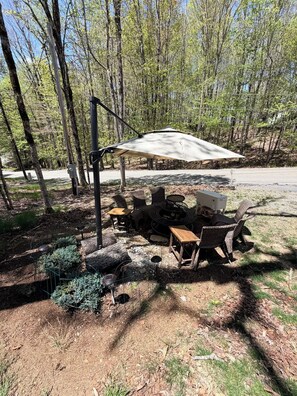 An outdoor seating area with a table and chairs, a fire pit, and a canopy. - Tremendous 2-bedroom cottage in Beech Mountain North Carolina (Banner Elk)
