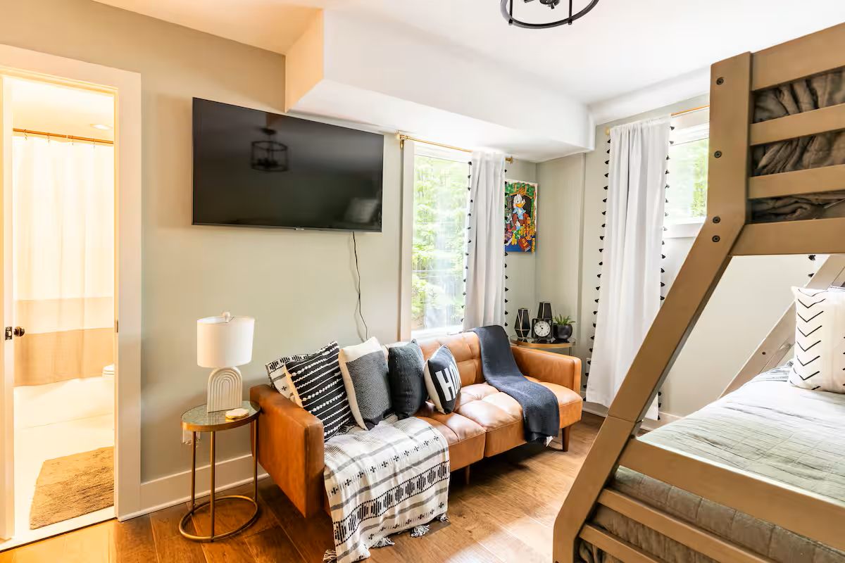 Un salon moderne avec un canapé, un téléviseur et un lit superposé.