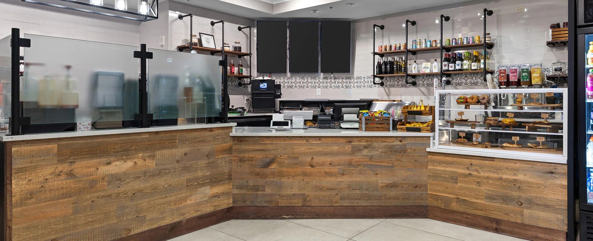 Una cocina moderna con detalles de madera, una cafetera y una vitrina con productos horneados.