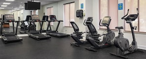 Ein Fitnessraum mit verschiedenen Cardiogeräten, darunter Laufbänder und Crosstrainer.