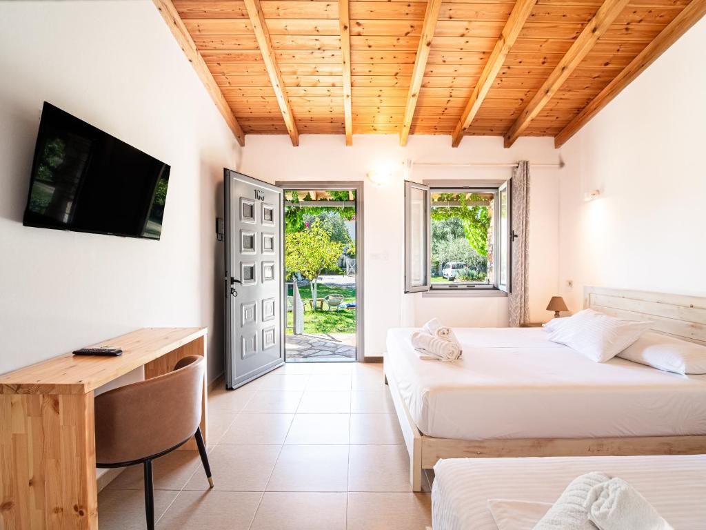 A bedroom with a bed, a desk, a chair, a TV, and two windows.