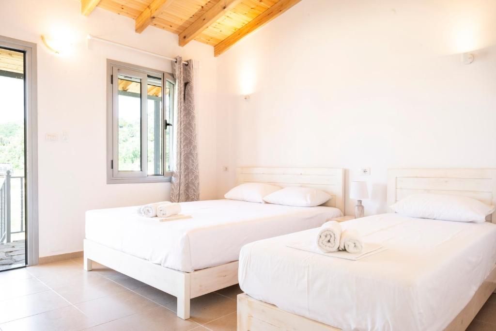 A bedroom with two beds, a window, and a door leading to an outdoor area.