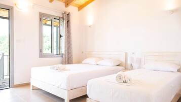 A bedroom with two beds, a window, and a door leading to an outdoor area.
