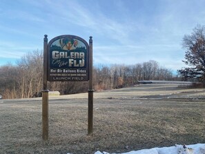 A sign for 'Galena on the Fly' hot air balloon rides with a launch field. - Pecker’s Nest  Cozy Cottage in Galena Territory (Galena)
