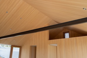 Ein modernes Interieur mit Holzverkleidung, einer schrägen Decke und einem sichtbaren Dachfenster.