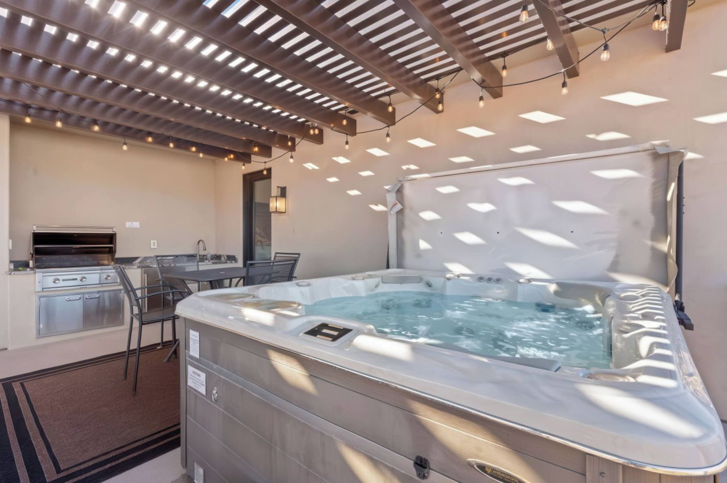 Ein Whirlpool mit integriertem Grill und einer Essecke mit Tisch und Stühlen.