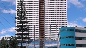 A high-rise building with multiple floors, a central elevator shaft, and a reflective glass facade.
