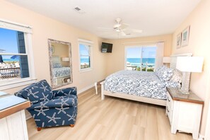 A bedroom with a bed, a chair, a TV, and a view of the ocean. - OCEANFRONT, Ocean Views, Hot Tub, Comm Pool -104, Shore Crew (Corolla)