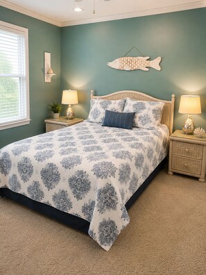 A bedroom with a bed, two nightstands, a wall-mounted fish decoration, and a window with blinds. - Welcome to your coastal getaway! (Orange Beach)