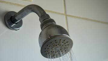 Un pommeau de douche dont l’eau jaillit.