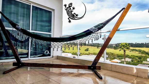 Eine Hängematte auf einem Balkon mit Blick auf eine grüne Landschaft.
