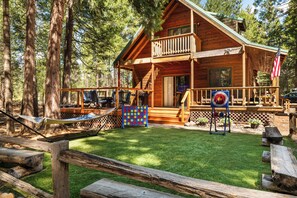 A cabin with a deck, outdoor seating, and a flag.
