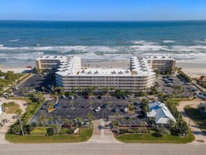 Hotel com estacionamento, vista para a praia e área de piscina.