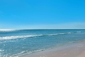 A beach with clear blue water and a sandy shore. - Gulf Highlands Studio Getaway | King Bed, Bunks, Steps to the Beach (Panama City Beach)