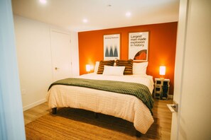 A bedroom with a bed, two bedside lamps, a framed poster on the wall, and a door. - Free Parking - Historic 2BR Apartment DT Halifax (Halifax)