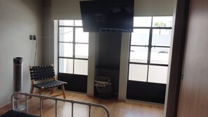 A room with a bench, a TV mounted on the wall, and a window with a view of the outside. - Apartment with a spacious terrace in the heart of Guadalajara, (Guadalajara)