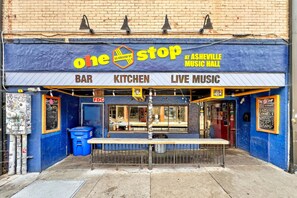 Een winkelgevel met een bord waarop 'one stop' en 'at Asheville Music Hall' staat.