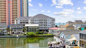A waterfront property with a large building, a dock, and a marina. - Six by the Ocean - Spacious 6BR Condo w/ Shared Pool and Hot Tub (Sleeps 16) (North Myrtle Beach)