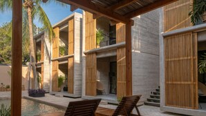 A modern outdoor seating area with wooden loungers and a pool. - Jilöo - Beautiful Retreat in Punta Zicatela (6) (Punta Zicatela)