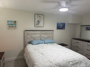 A bedroom with a bed, a nightstand, a dresser, and a ceiling fan. - Marvelous 1-bedroom condo with AC in St. Pete Beach (St. Pete Beach)