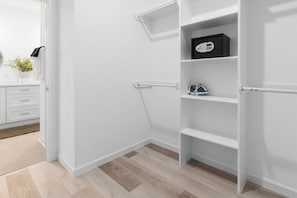 A white interior with a wooden floor, a white door, and a white wall. - Houston 3BR Home - Arcade, Pool Table & Patio (Houston)