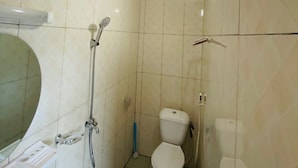Un baño con inodoro, ducha y lavamanos.