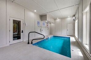 Ein Schwimmbecken mit schwarzer Sicherheitsreling, Glastür und einem Schild, das Sprünge verbietet.