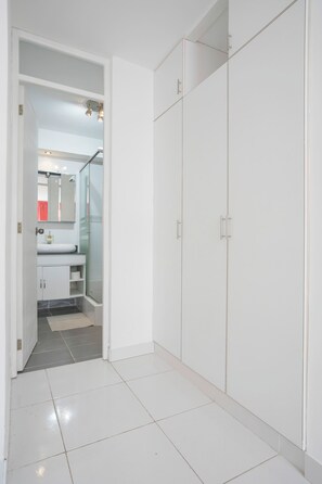 A modern bathroom with a glass shower enclosure, a white sink, and a mirror.