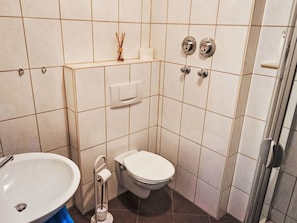A bathroom with a toilet, sink, and a towel dispenser. - Ferienwohnung Debacher by Interhome (Rust)