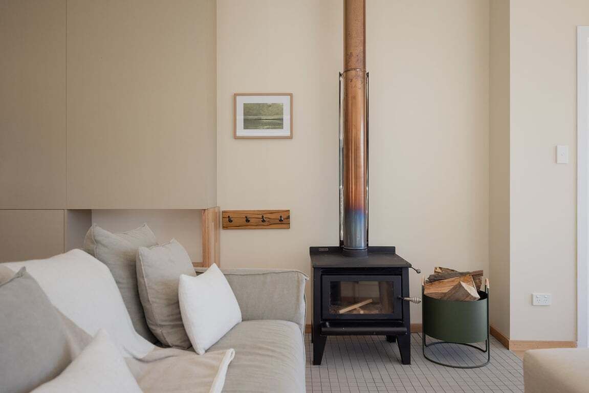 A cozy living room with a sofa, a fireplace, and a framed picture on the wall.