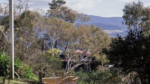 A residential property with a view of distant mountains, a paved patio, and surrounding vegetation. - Graceys Beach House Dennes Point (Kingborough)