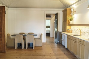A modern kitchen with wooden cabinets, a marble countertop, and a built-in oven.