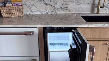 A kitchen with a built-in refrigerator, a marble backsplash, and a wooden countertop.